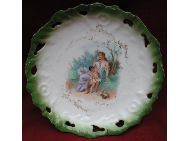 Photo Assiette ancienne avec bord vert et personnage central. image 1/1